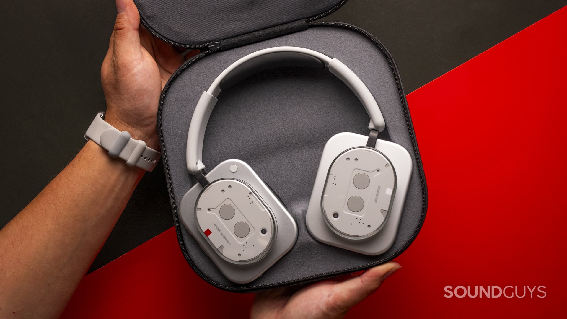 holding the nothing headphone (1) in travel case open