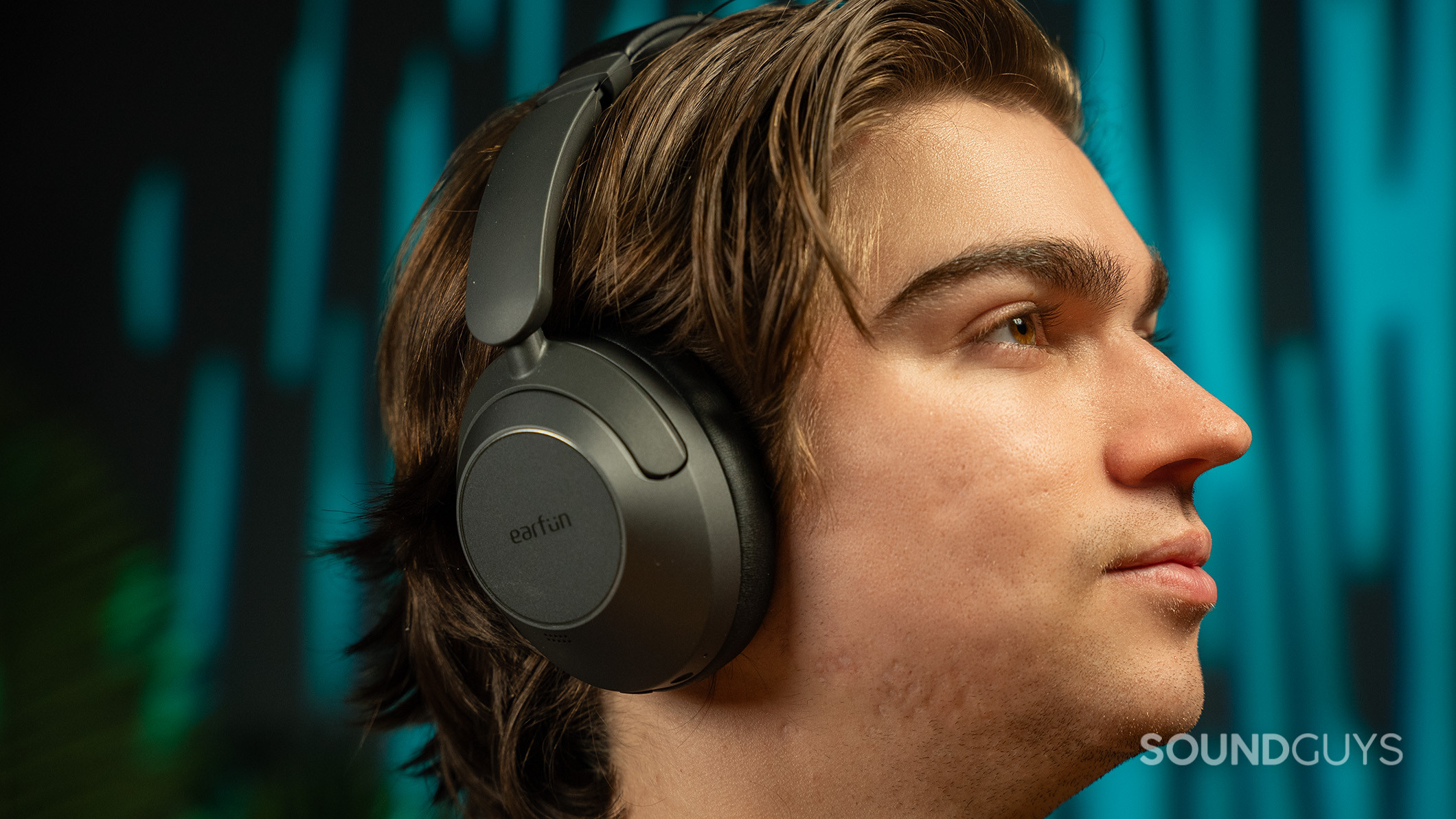 A man wearing the EarFun Wave Pro looking to the right.